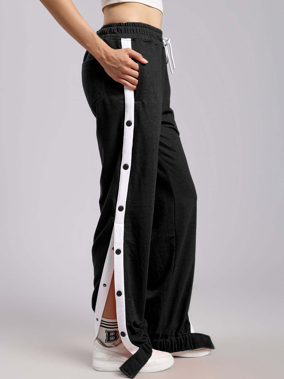 Side view of WOMENS MILLER RELAXED FIT JOGGERS BLACK with white stripe detail, showcasing comfortable and stylish design.