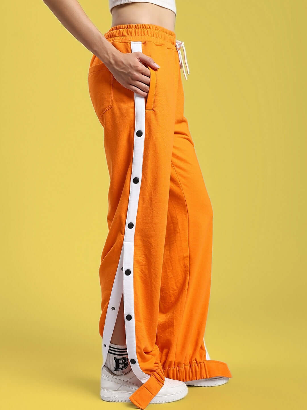 Women's Miller Relaxed Fit Joggers in Orange with white side stripe, featuring a comfortable drawstring waist and button detailing.