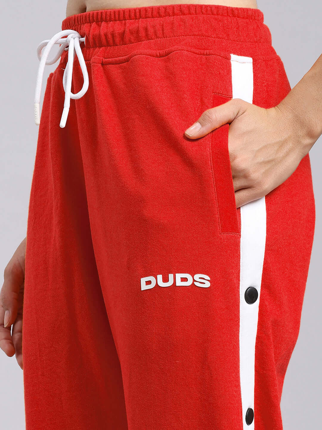 Close-up of red women's Miller relaxed fit joggers with DUDS logo and side white stripe.