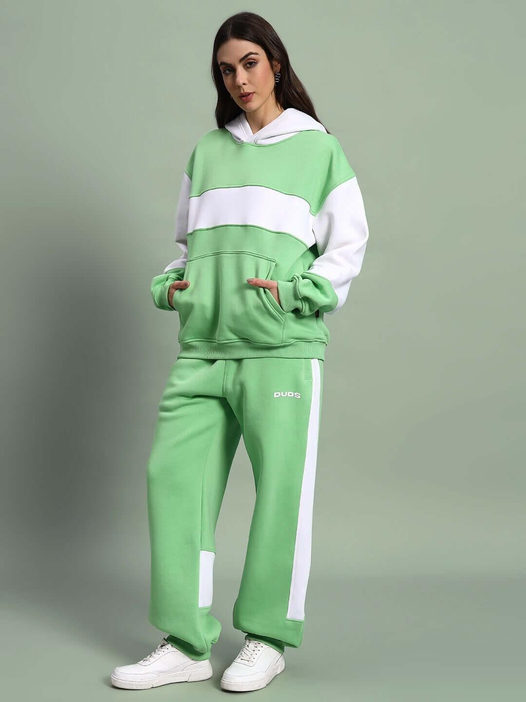 Women wearing WOMEN MINTED BLISS FLEECE COLORBLOCK CO-ORD GREEN WHITE streetwear set with hoodie and joggers.
