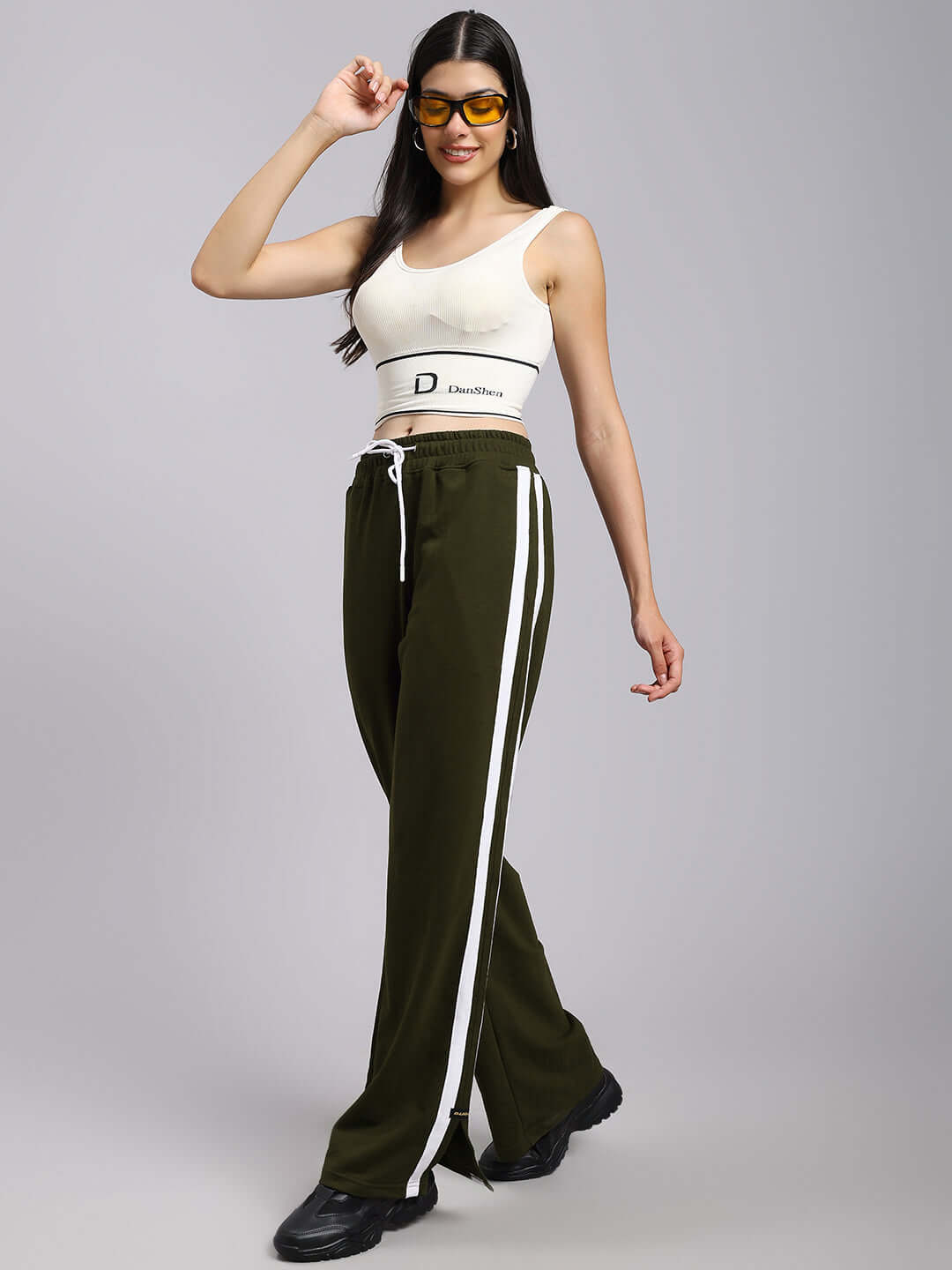 Model wearing Women's Moscow Relaxed Fit Joggers in Olive Green with white stripes, showcasing comfortable fit and style.