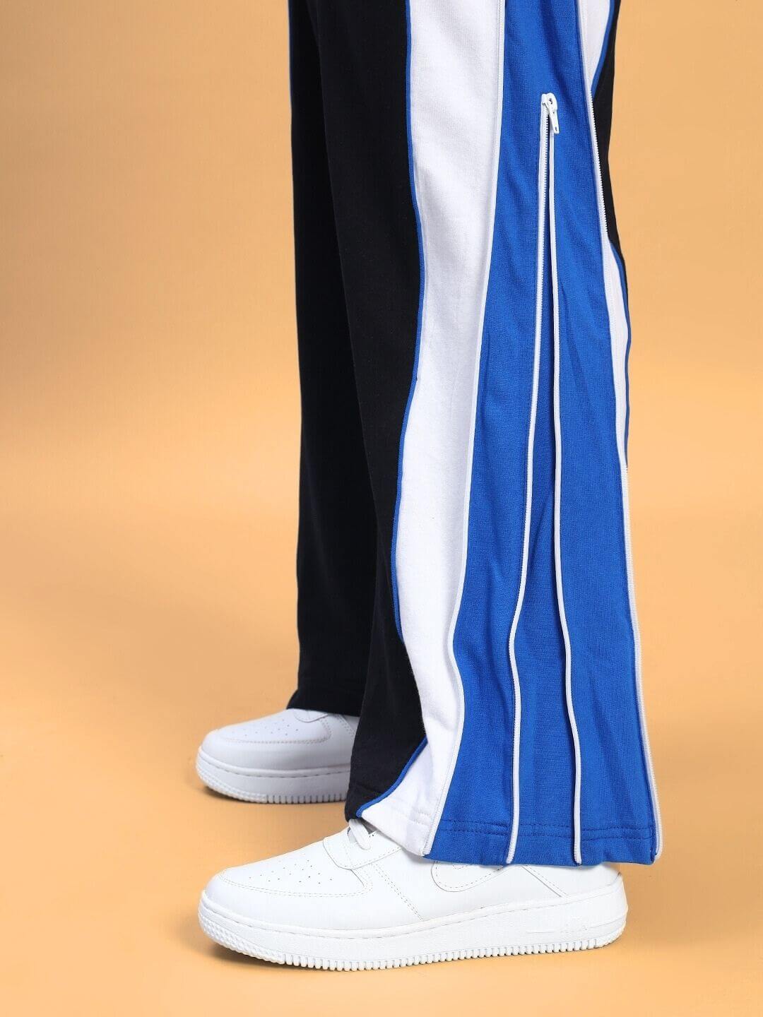 Side view of WOMEN'S MYSKY CO-ORD SET WHITE ROYAL BLUE featuring sporty pants with white and blue accents and white sneakers.