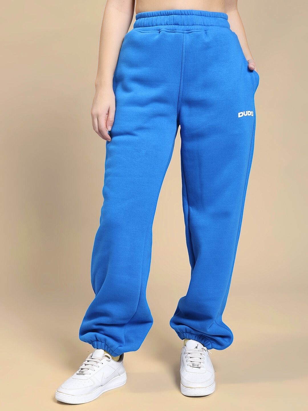 Person wearing WOMEN NATURE LINK FLEECE CO-ORD SET ROYAL BLUE joggers standing on beige background