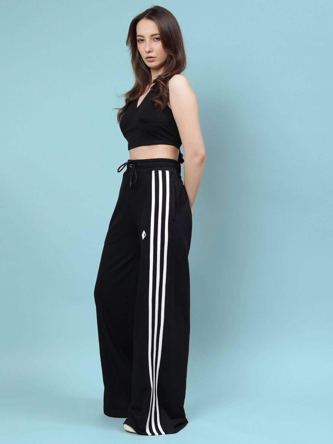 Model wearing WOMEN'S NEER CO-ORD SET - BLACK, featuring a stylish top and pants with white side stripes, perfect for versatile wear.