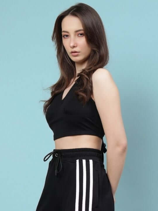 Woman wearing a black crop-top with premium heavy gauge 100% cotton fabric against a blue background.
