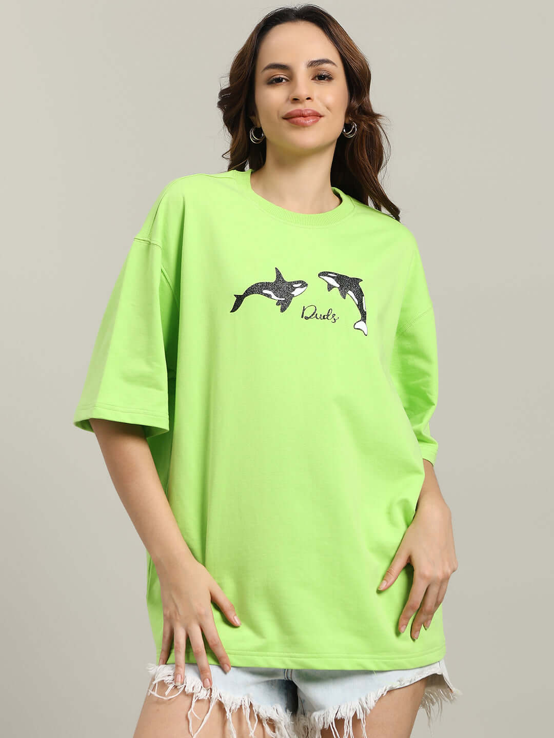 Woman wearing WOMEN'S ORCAS OVER-SIZED T-SHIRT NEON GREEN with orca graphics