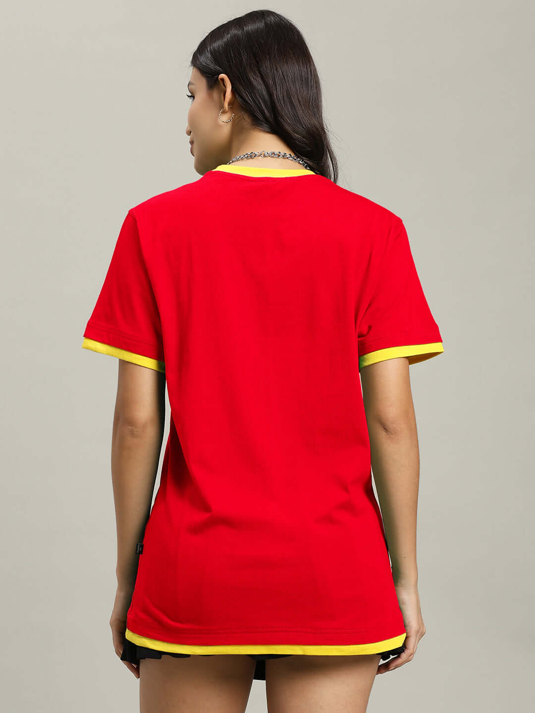 Back view of a woman wearing a red Noriba regular fit T-shirt with yellow accents, made from 100% cotton, emphasizing comfort and style.
