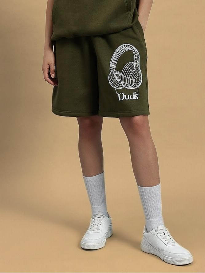 WOMEN OPERA FLEECE SHORTS OLIVE GREEN worn with white sneakers, showcasing the stylish design and comfort.