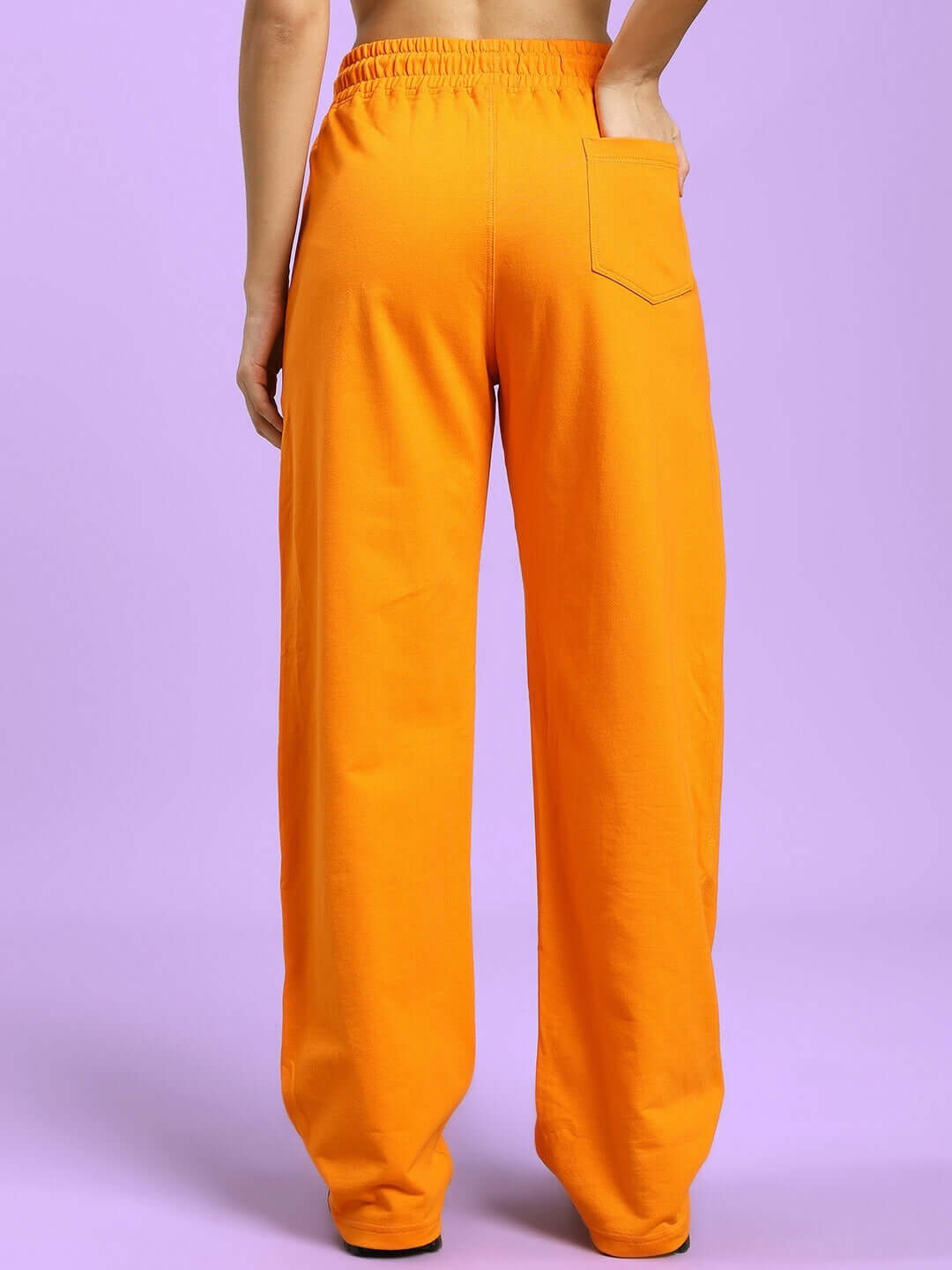 Back view of women's orange flaming skeleton printed relaxed fit jogger designed by DUDS, featuring elastic waistband and pocket detail.