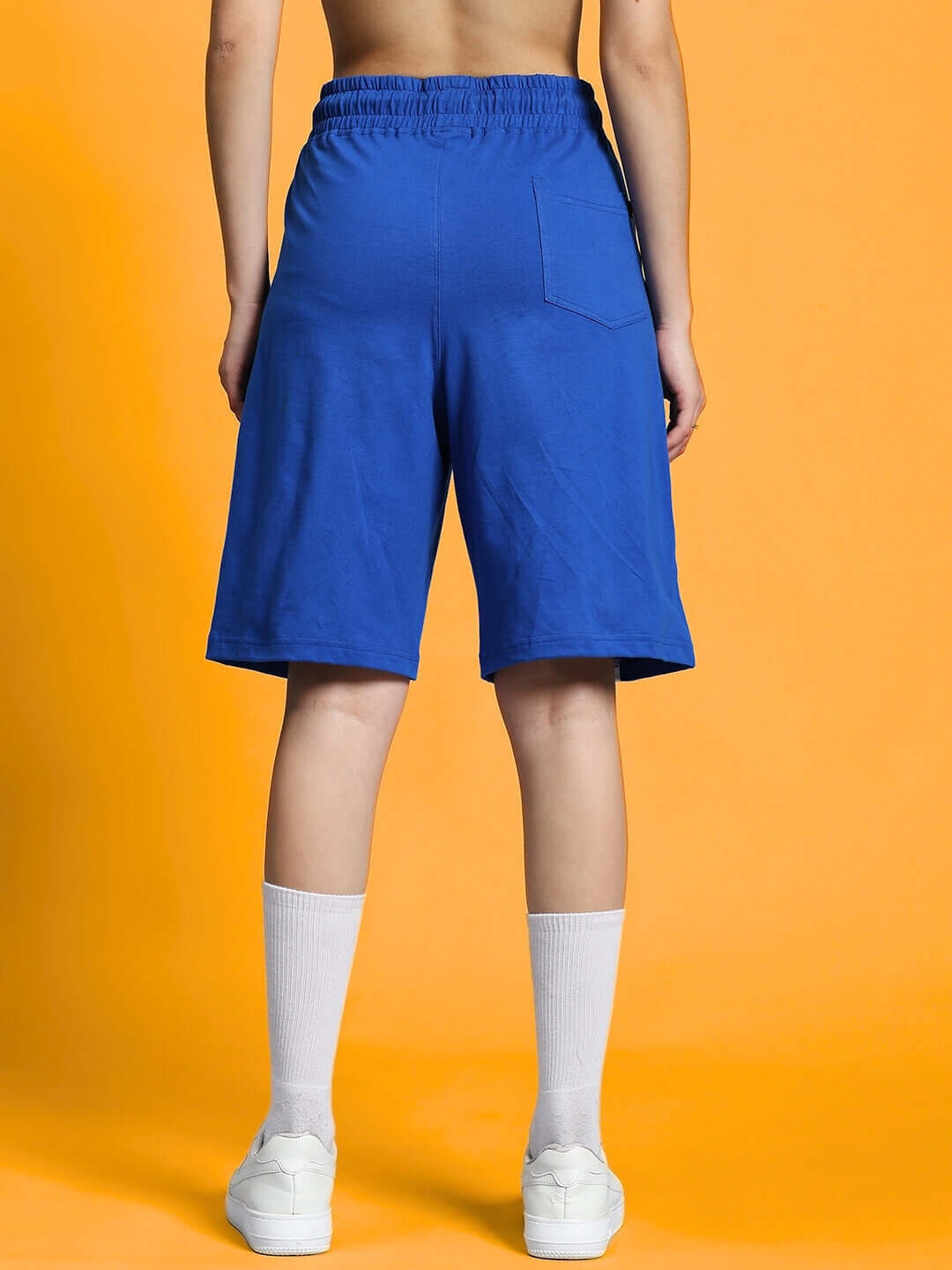 Back view of women's blue regular fit shorts, featuring elastic waistband and single back pocket, ideal for custom fit orders.