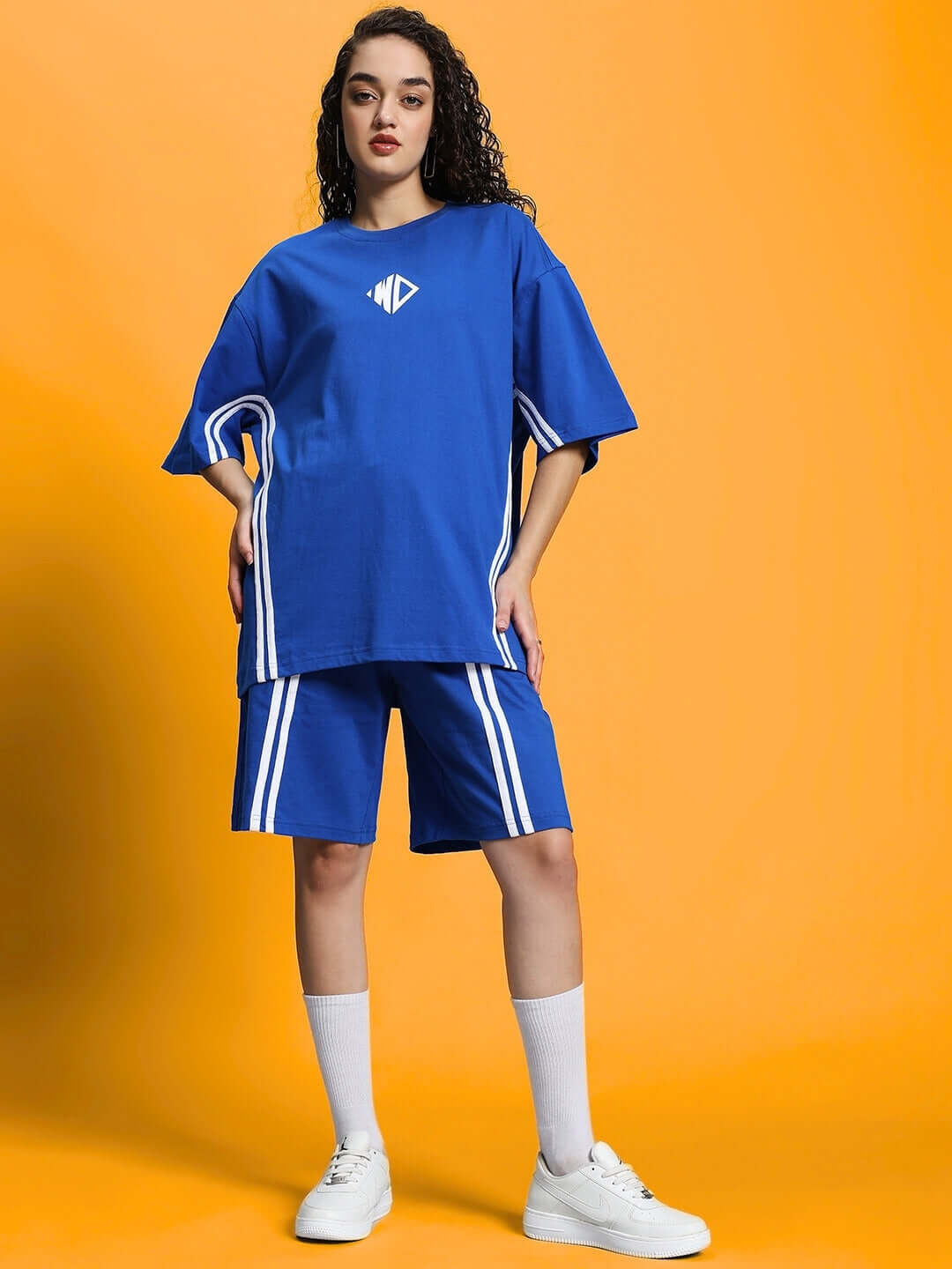 Model wearing Women's Outlook Summer Co-ord Shorts Set in royal blue, made of premium cotton French terry lycra, on an orange background.