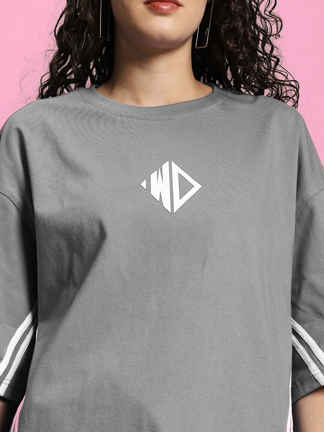 Model wearing WOMEN'S OUTLOOK SUMMER CO-ORD SHORTS SET GREY, showcasing a relaxed-fit t-shirt with geometric logo.