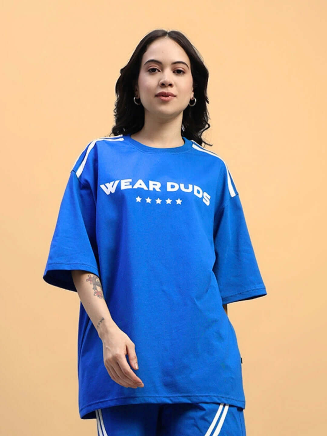 Model wearing blue oversized women's jumper t-shirt with 'Wear Duds' text and star design, made of premium cotton fabric.