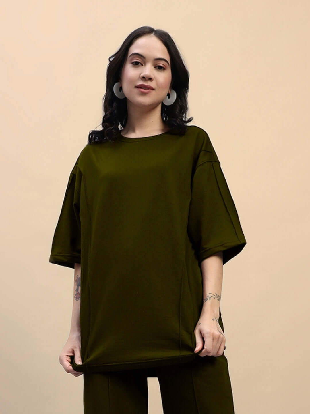 Model wearing women's oversized olive green T-shirt made of premium cotton French terry lycra blend, perfect for casual wear.