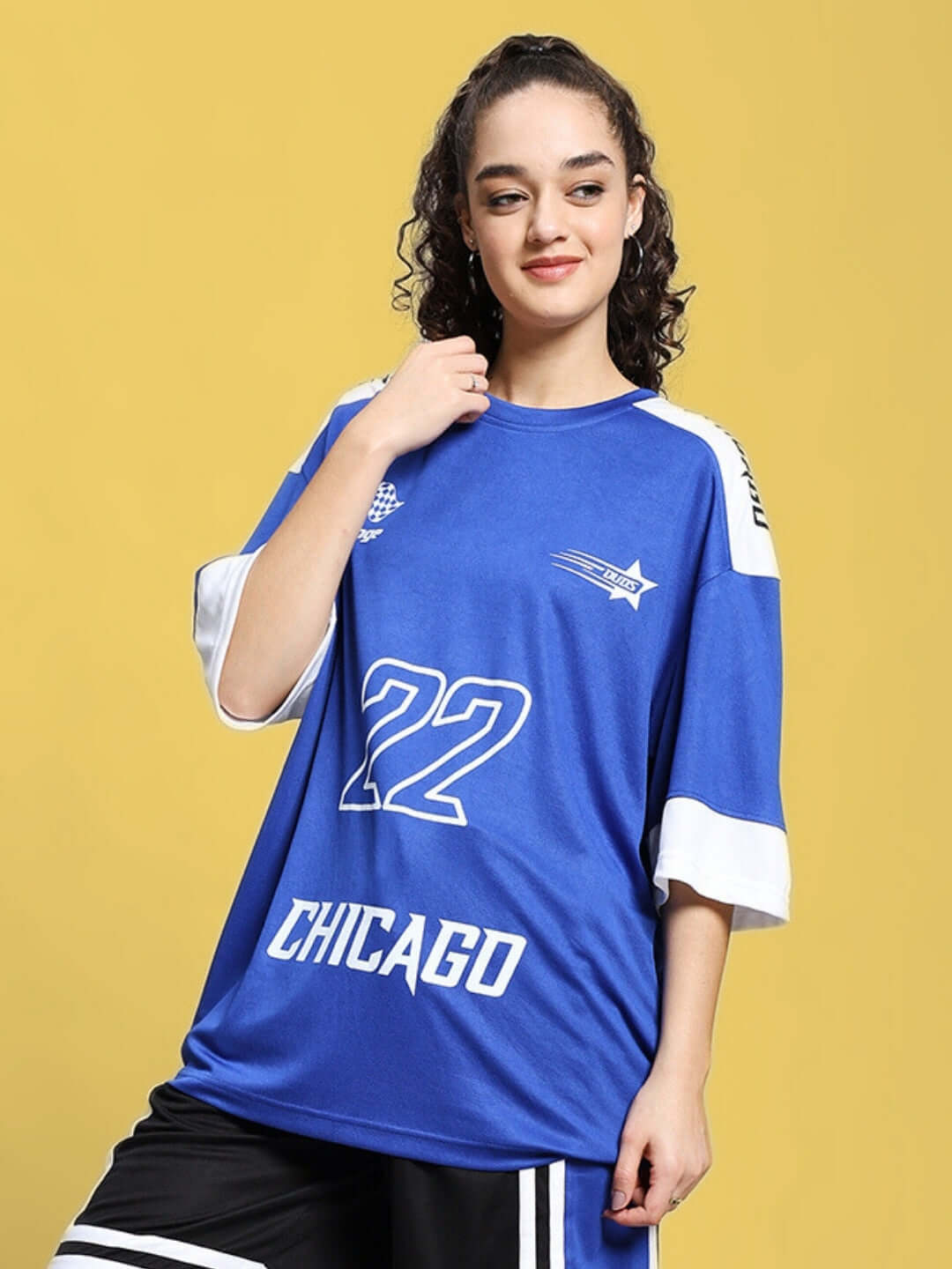Woman wearing an oversized royal blue T-shirt with 'Chicago 22' print, promoting the customizable Women's Challenge collection.