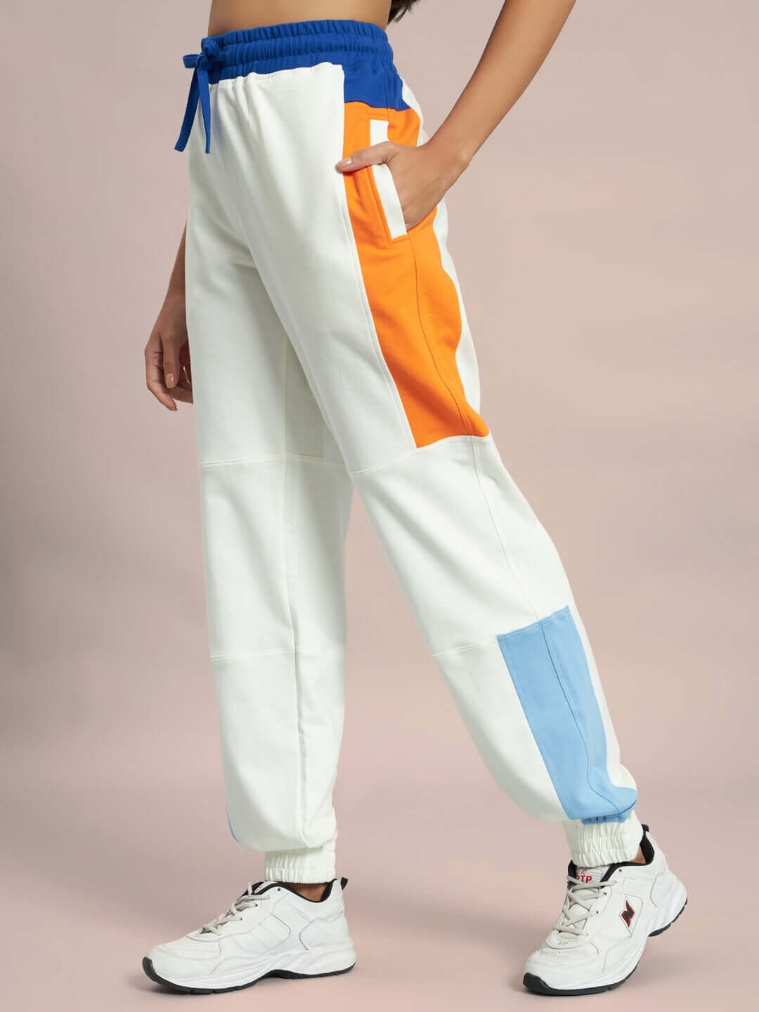 Off-white women's joggers with side contrast panels in blue and orange, featuring a drawstring waist for a custom fit.