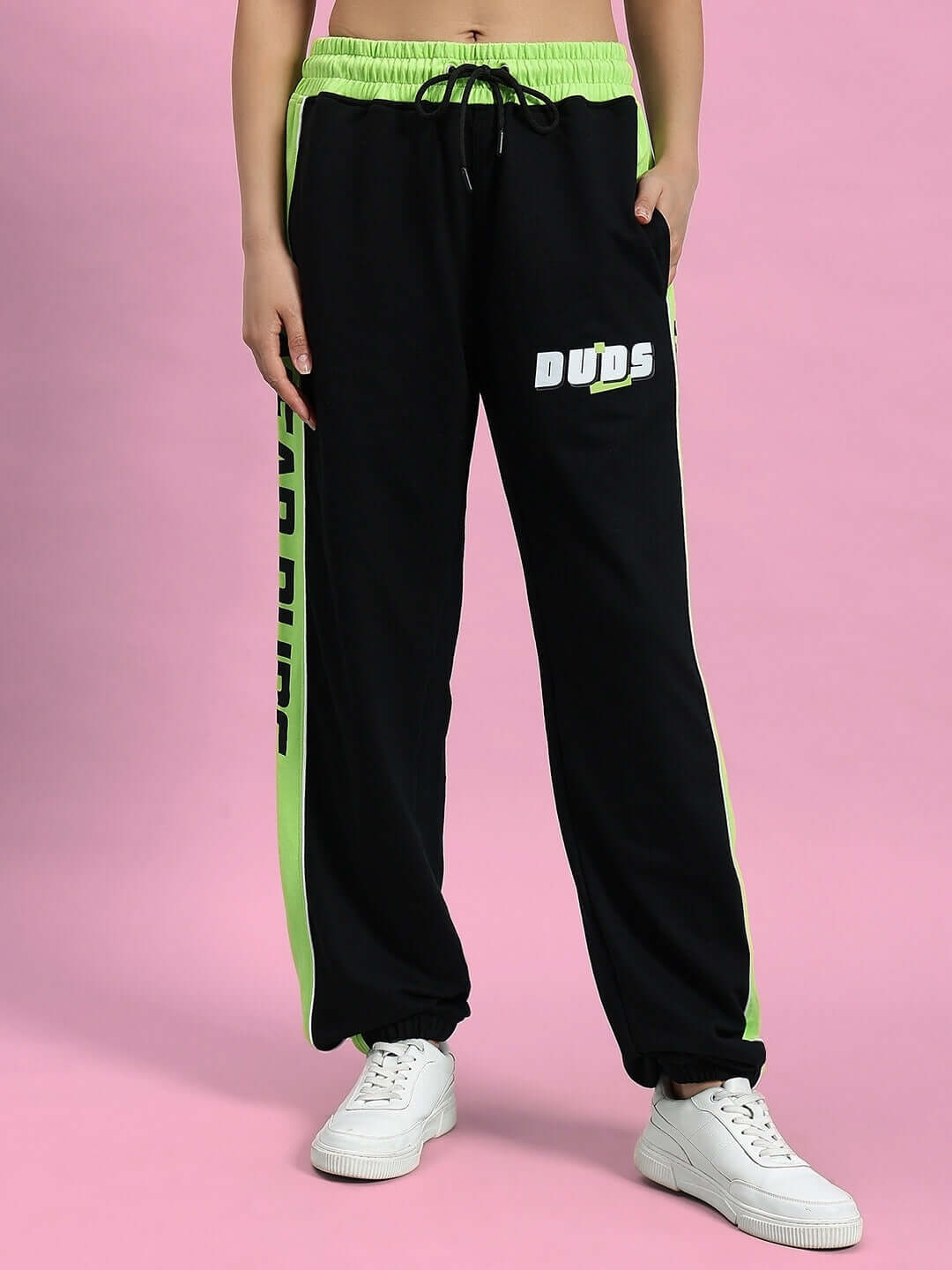 Black and neon green women's joggers by DUDS, featuring a drawstring waist and side logo detail, designed for custom fit options.