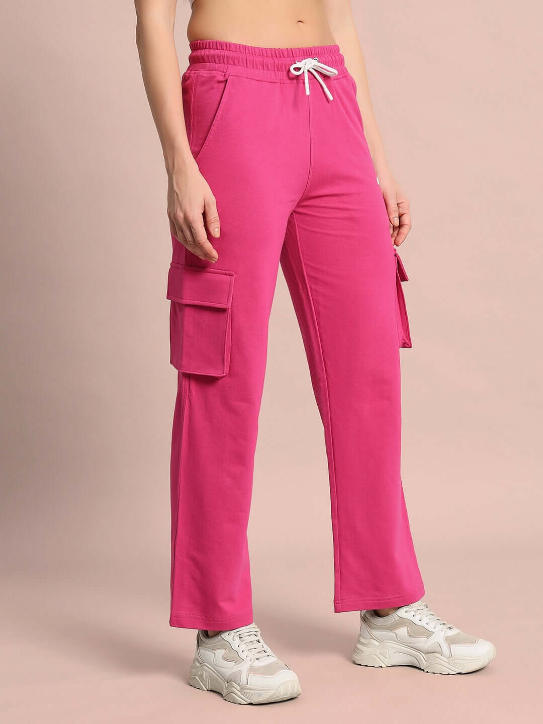 Pink women's Merriam joggers by DUDS, featuring cargo pockets and drawstring waist. Custom fit and made to order by skilled tailors.