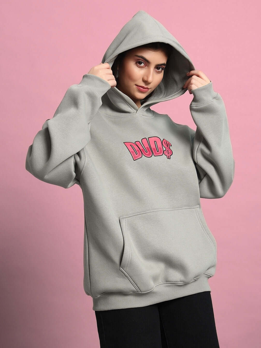 Woman wearing WOMEN PINK PANTHER OVERSIZED HOODIE GREY in front of a pink background