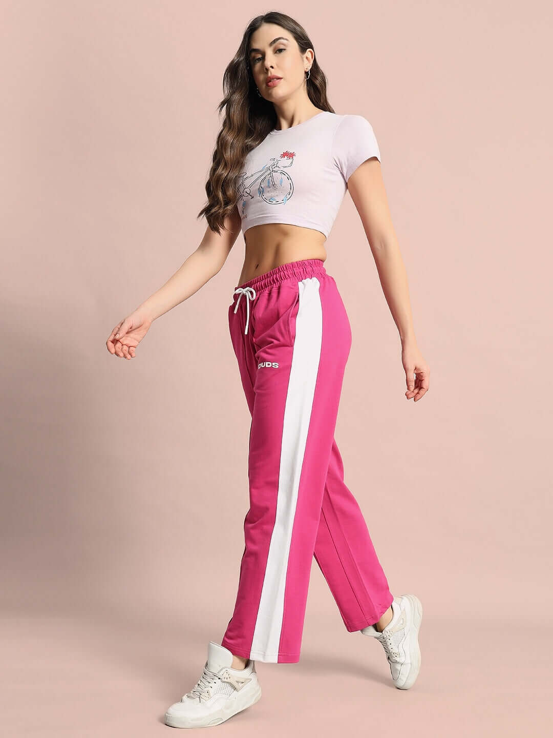 Model wearing pink women's side seam plated joggers by DUDS, showcasing stylish and comfortable fit.