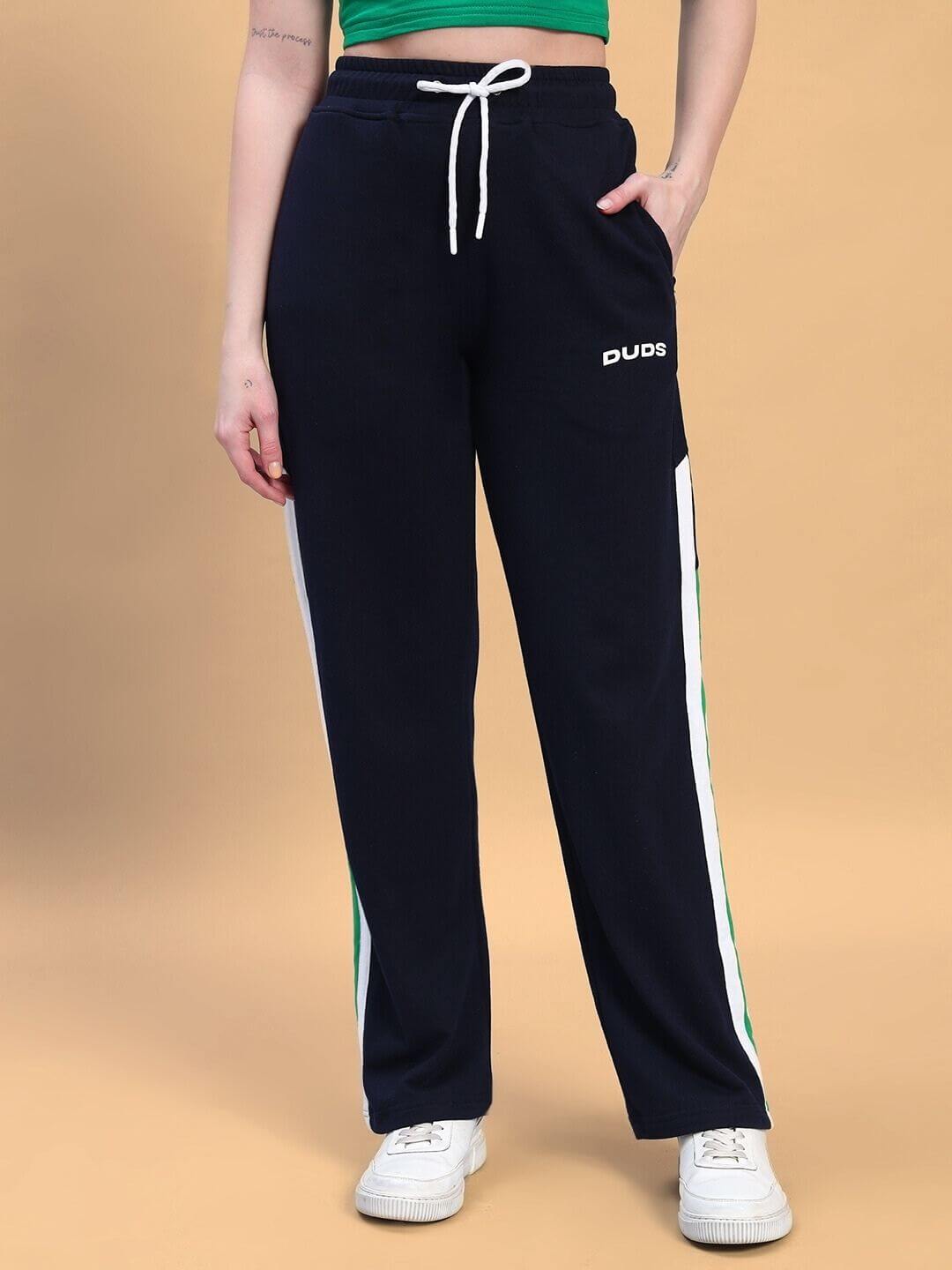 Woman wearing WOMEN'S PLAYER CO-ORD SET GREEN NAVY with sporty black pants and white sneakers.
