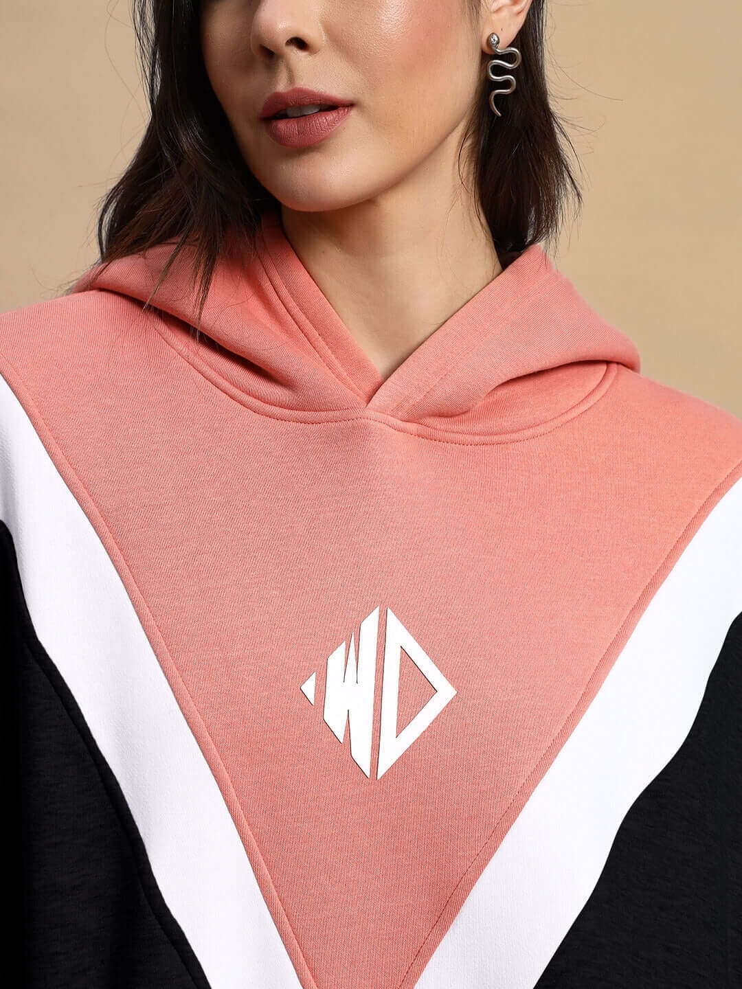 Alt Tag: Woman wearing WOMEN POLAR COLORBLOCK HOODIE BLACK PEACH with a vibrant black and peach design.