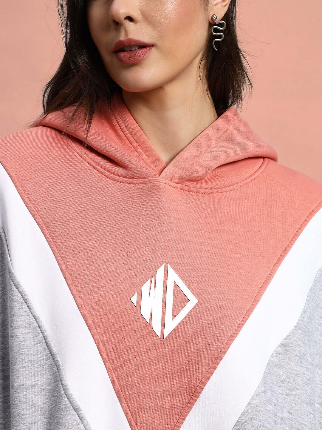 Close-up of woman wearing WOMEN POLAR COLORBLOCK HOODIE GREY PEACH with peach and grey color design, showcasing comfort and style.