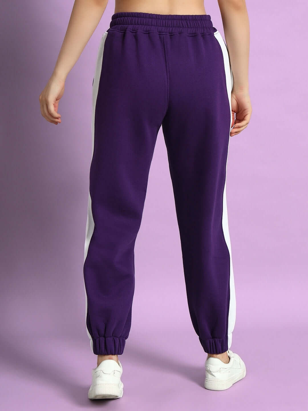 Back view of WOMEN RIZZLER FLEECE COLORBLOCK JOGGER PURPLE with white side panels, showcasing stylish and cozy design for casual wear.