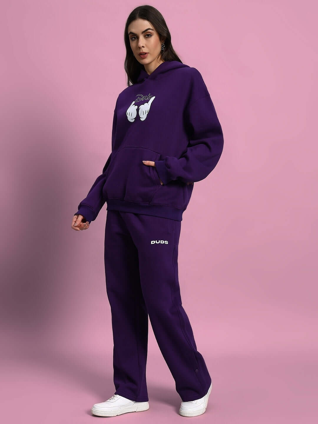 Woman wearing WOMEN SOOTY FLEECE CARGO PANT PURPLE with matching hoodie and white sneakers.