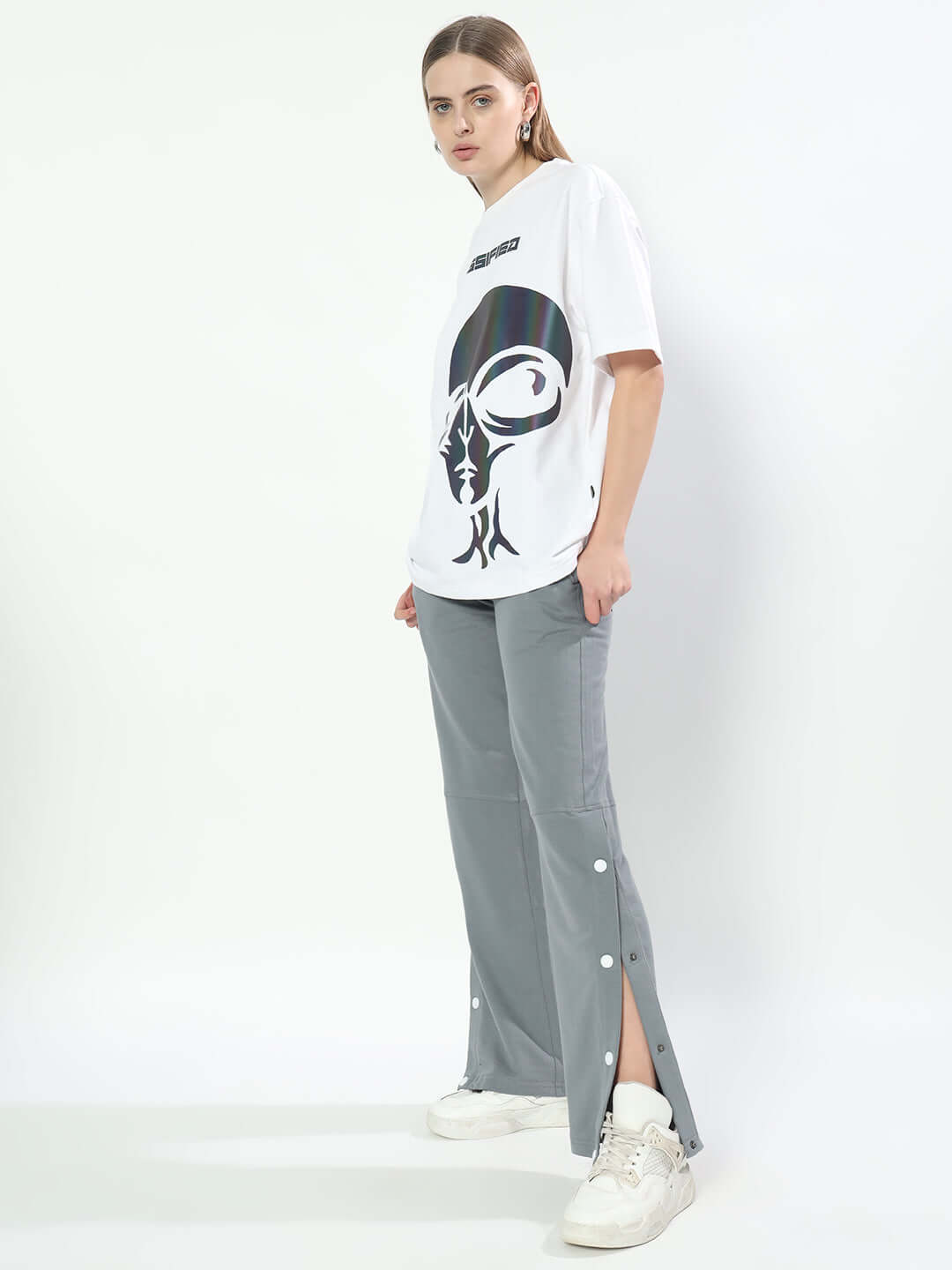 Model wearing Women's Racer Joggers in grey with a graphic tee and sneakers, showcasing stylish casual wear. Made-to-order by DUDS.