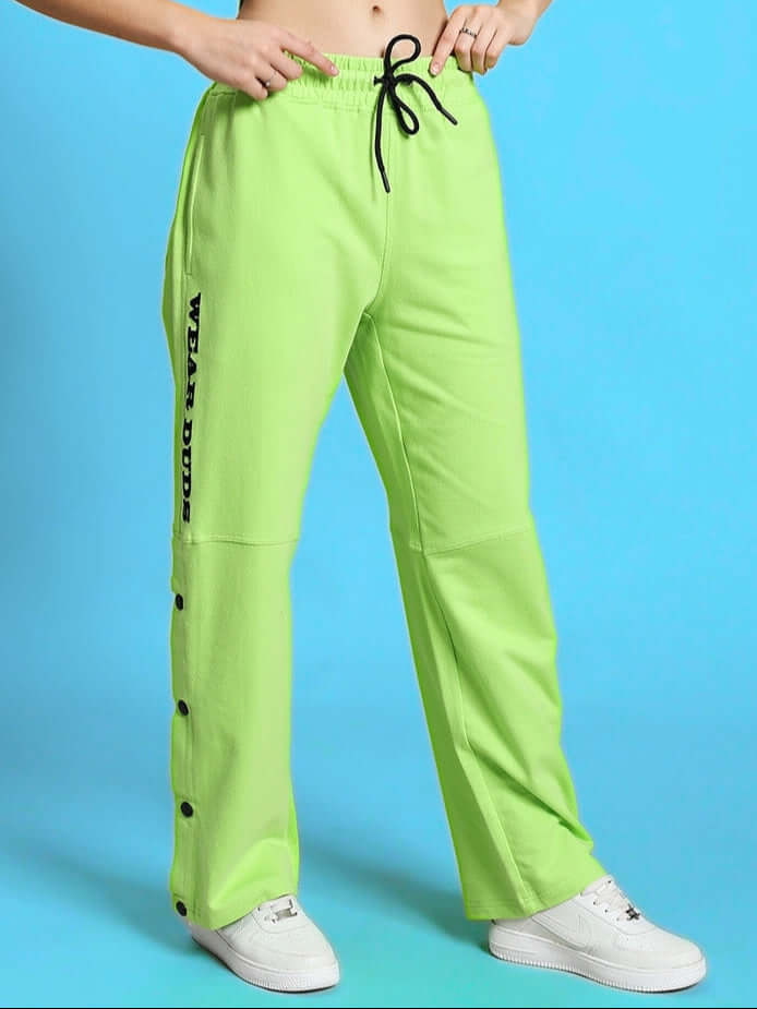 Neon green women's racer joggers with custom fit option, featuring button details and black lettering, made by DUDS.