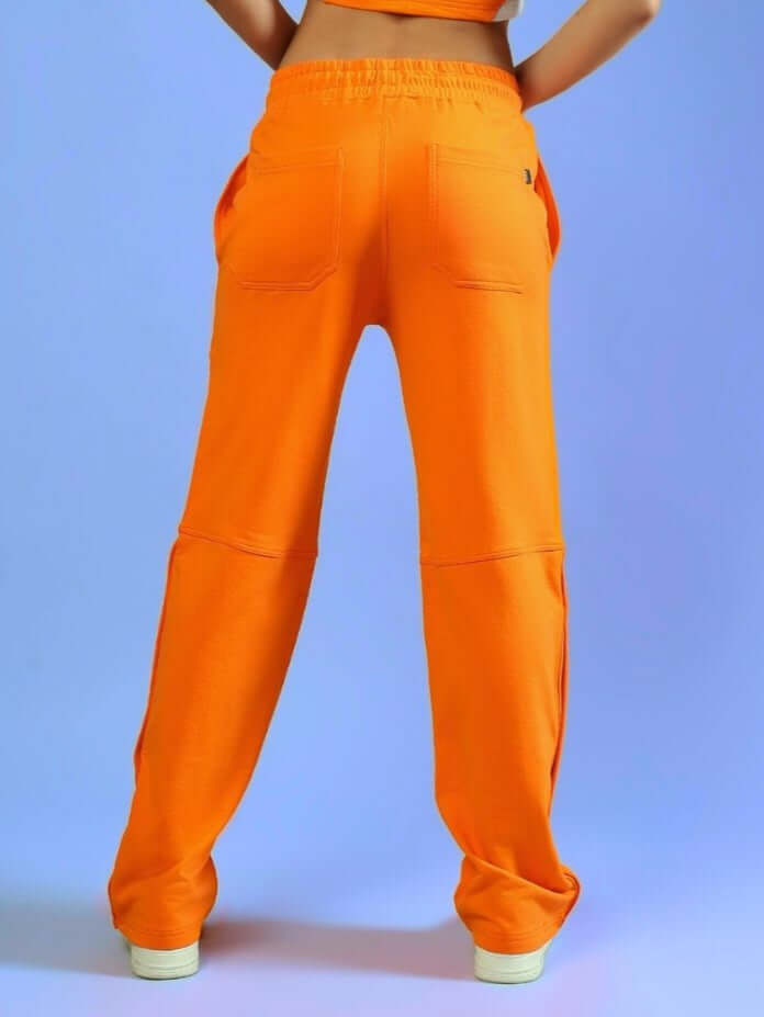 Back view of orange women's racer joggers showcasing comfortable fit and stylish design, ideal for custom sizing options by DUDS.