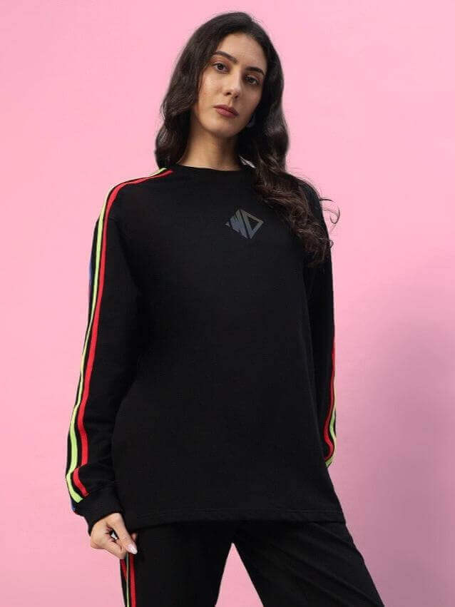Model wearing Women's Rainbow Oversized Co-Ord Set in black with multicolor stripes, showcasing a relaxed fit design and elastic waistband.