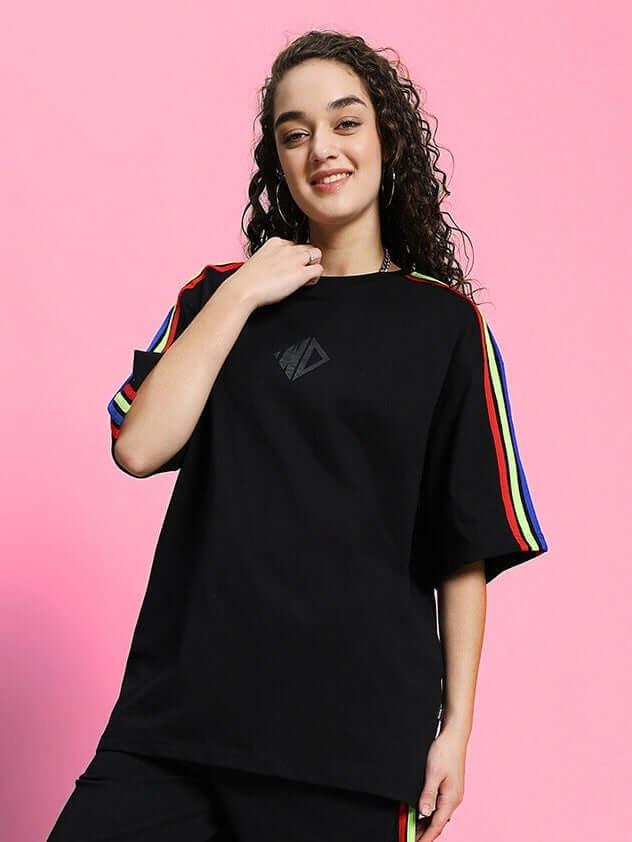 Model wearing a women's rainbow over-sized t-shirt in black with rib rainbow detailing, made from premium cotton French terry.