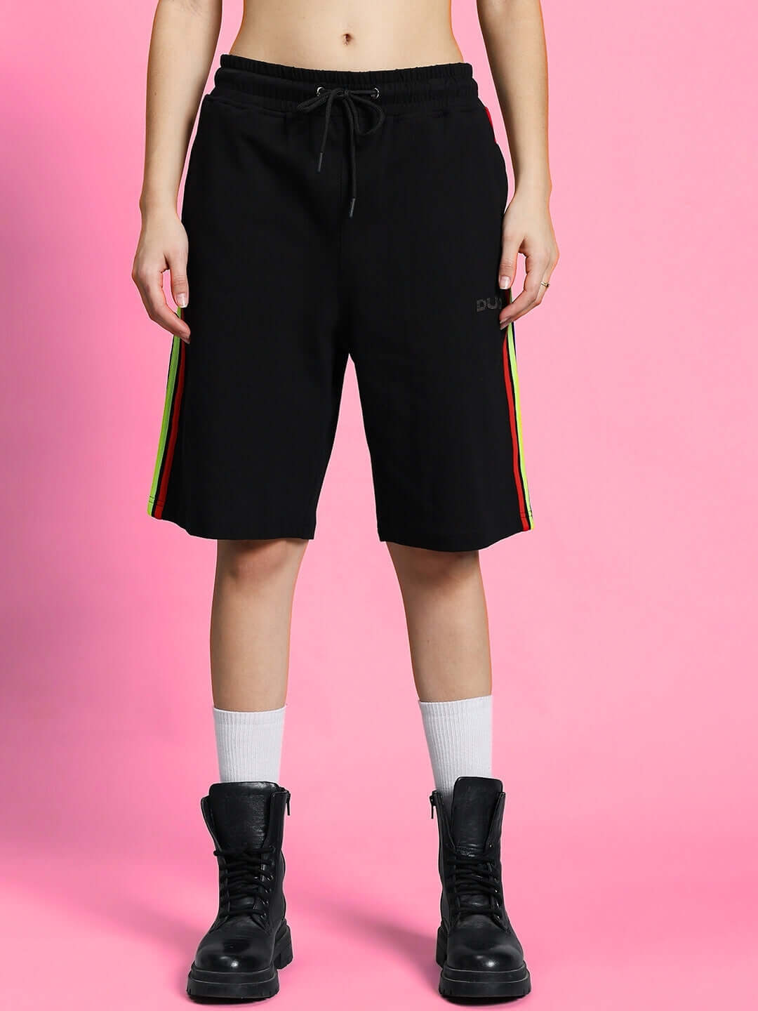 Person wearing WOMEN'S RAINBOW SUMMER CO-ORD SET BLACK featuring rainbow stripes on sides, against pink background.