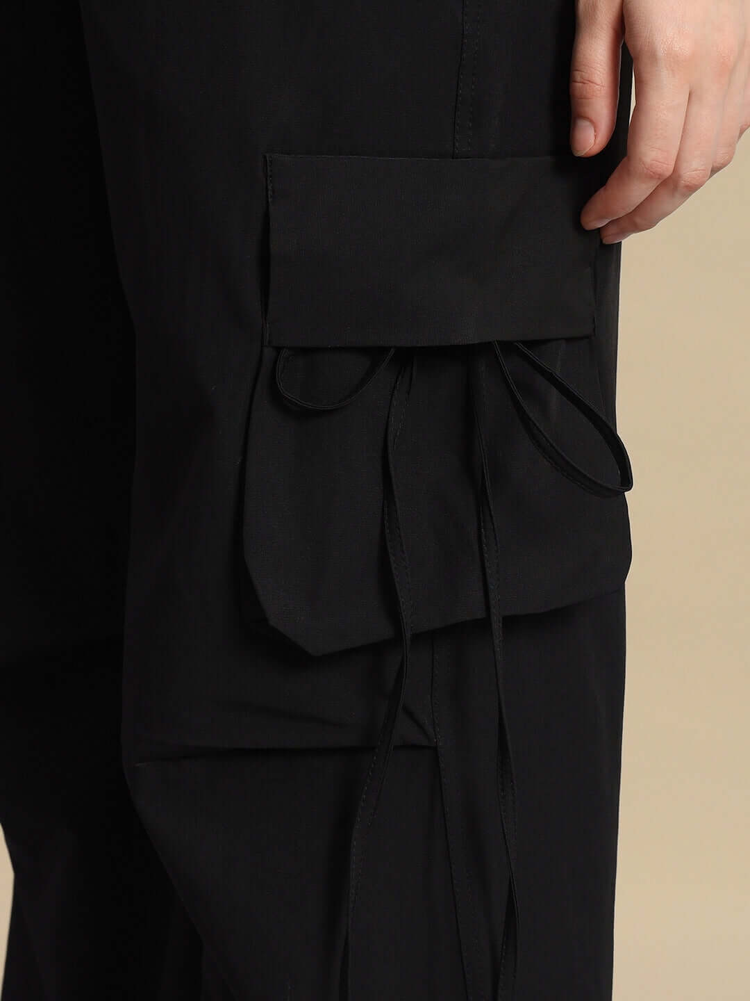 Close-up of black women's Ramrod parachute cargo pants showcasing pocket detail with drawstrings.