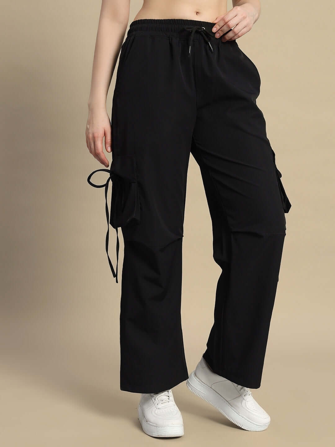 Woman wearing black Ramrod parachute cargo pants with sneakers, showcasing custom fit option for women's fashion.