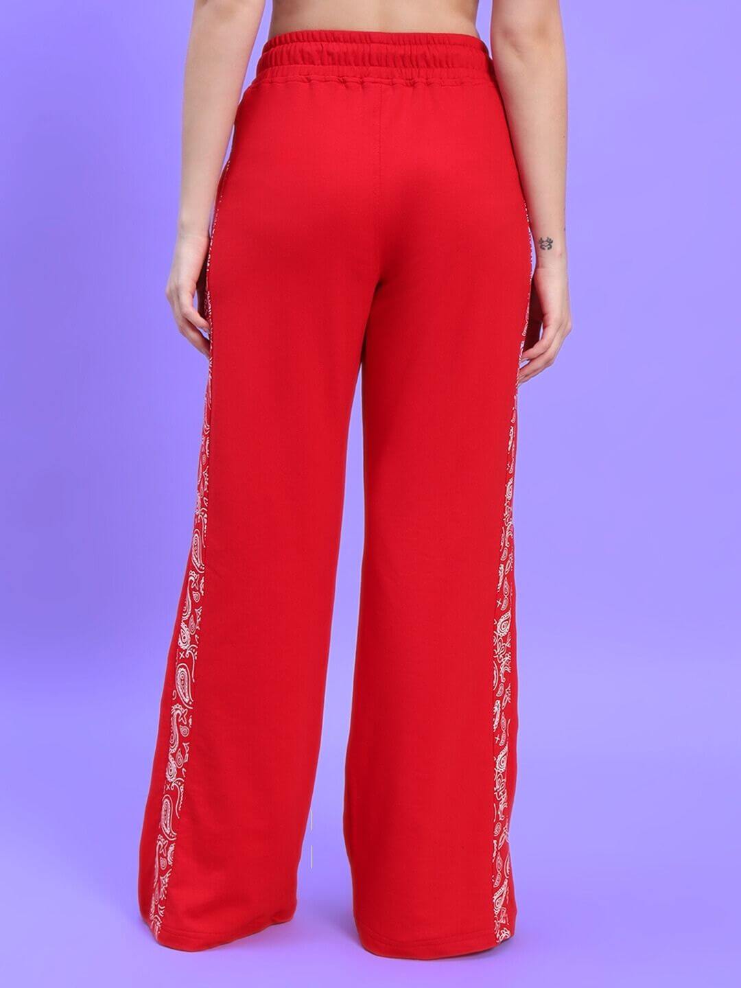 Back view of WOMEN'S HOLLY CO-ORD SET - RED pants with paisley trim detail on purple background.