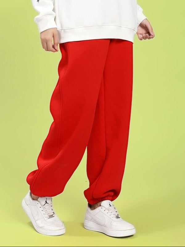 Woman wearing WOMEN'S ZENO RELAXED FIT FLEECE JOGGER RED with white sneakers and a sweatshirt.