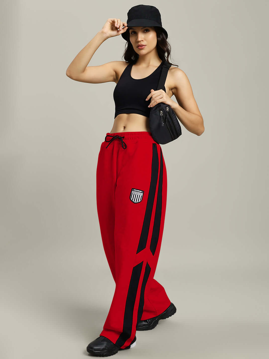 Model wearing WOMEN'S ROYALSON JOGGERS in red with black stripes, stylish and sporty design, tailored for comfort by expert DUDS tailors.