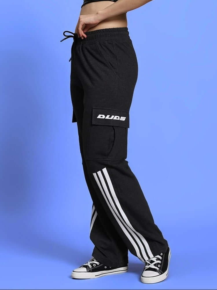 Women's DUDS black joggers with white stripes, featuring a relaxed fit and pocket detail. Ideal for casual wear.