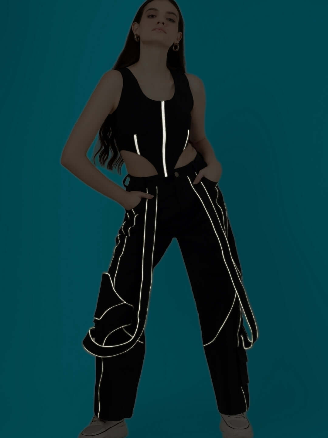 Woman wearing a reflective co-ord set with corset top and reflective carpenter pants, showcasing fashion and style.