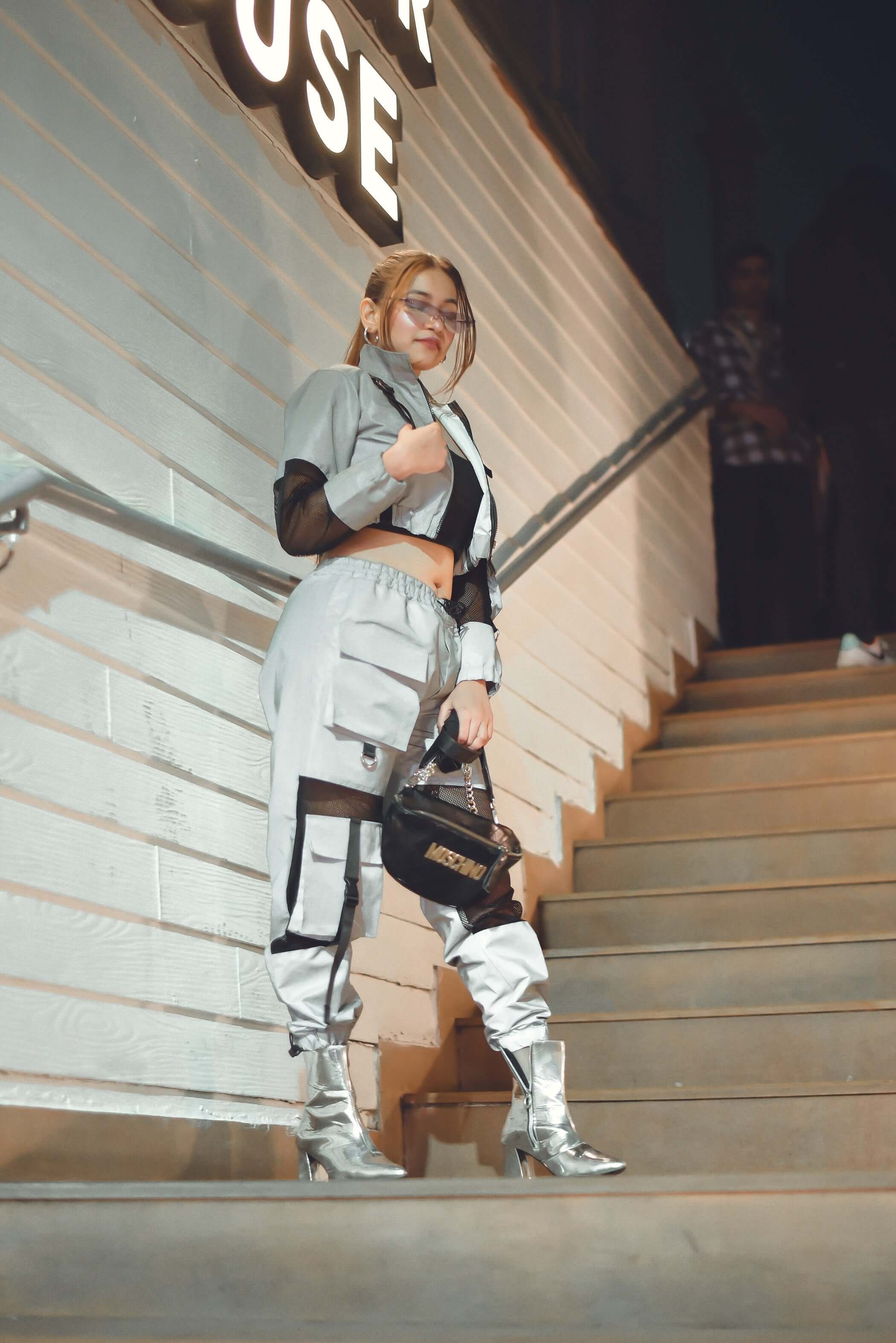 Model wearing the WOMEN'S REFLECTOR CO-ORD SET CARGO PANTS WITH JACKET, showcasing edgy street style and fashion.