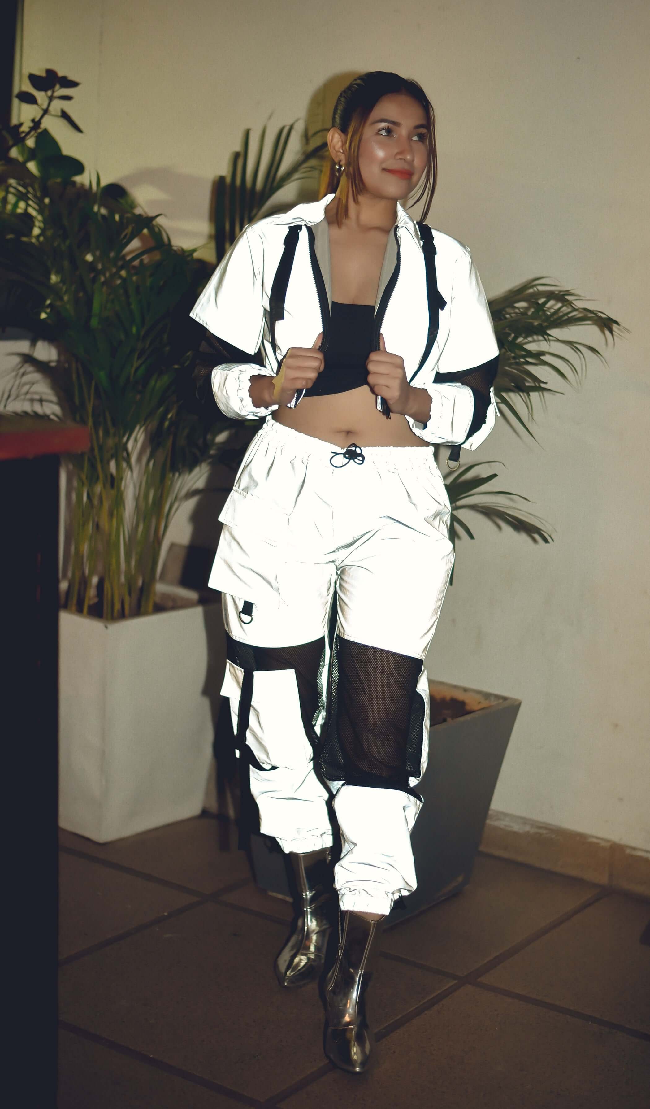 Woman wearing WOMEN'S REFLECTOR CO-ORD SET CARGO PANTS WITH JACKET with plants in the background.