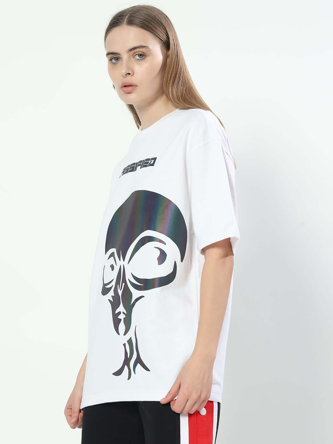 White over-sized women's t-shirt with graphic print, made from premium cotton fabric. Model wearing t-shirt with black and red pants.
