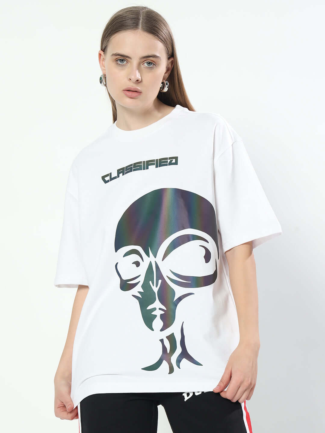 Women's oversized white t-shirt with alien graphic and 'Classified' text, made of premium cotton fabric, styled by model.