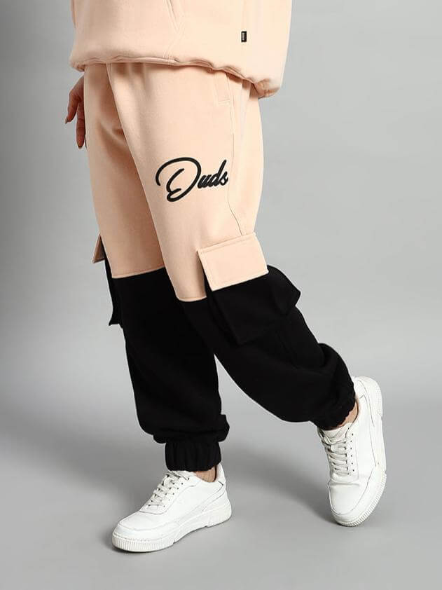 WOMEN REGIMENT FLEECE PANT BEIGE BLACK showcasing urban streetwear style with elastic waistband and ribbed hems.