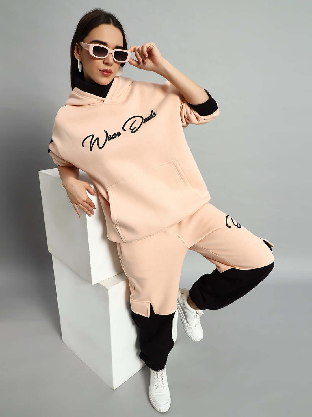 Model wearing WOMEN REGIMENT FLEECE PANT BEIGE BLACK with matching top and sunglasses.