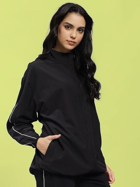 Woman wearing WOMEN RELIGHT RELAXED FIT JACKET BLACK with reflective trims for enhanced visibility.