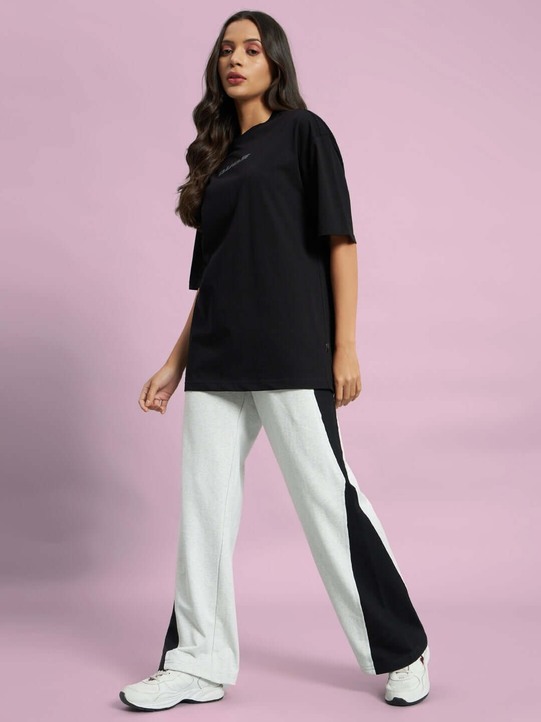 Woman wearing grey-black contrast joggers and black t-shirt, showcasing DUDS fashion.